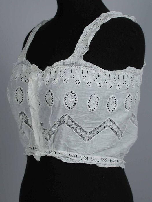Kort bustier-achtig onderlijf van wit katoen met kant en broderie anglaise incrustraties,…