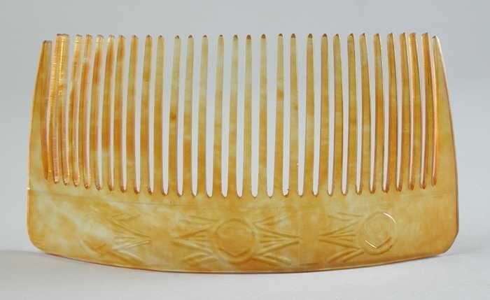 Gebogen sierkam van geel-oranje gevlamd kunststof 31 tanden, smal blad met geometrische motieven