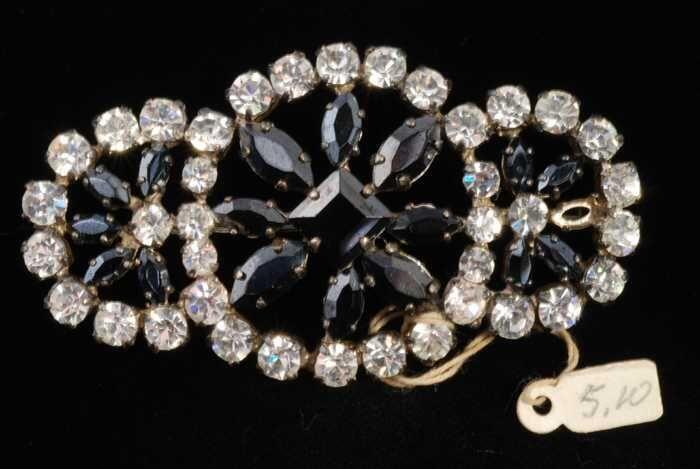 Ovale broche met veel kunstdiamantjes in een zilverkleurige vattin rondom facetgeslepen zwarte…