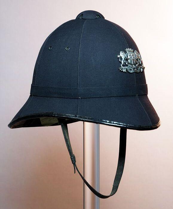Politiehelm, bobby model van zwart keper met metalen embleem van stadswapen van Rotterdam, kinriem