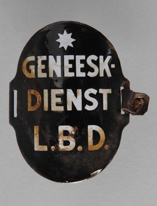 Ovaal zwart geëmailleerd armschildje met "GENEESK- DIENST L.B.D."