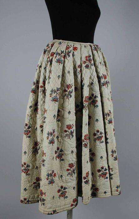 Kuitlange wijde matelassé-rok van bedrukt wit linnen sits met bloemmotieven in rood en blauw,…