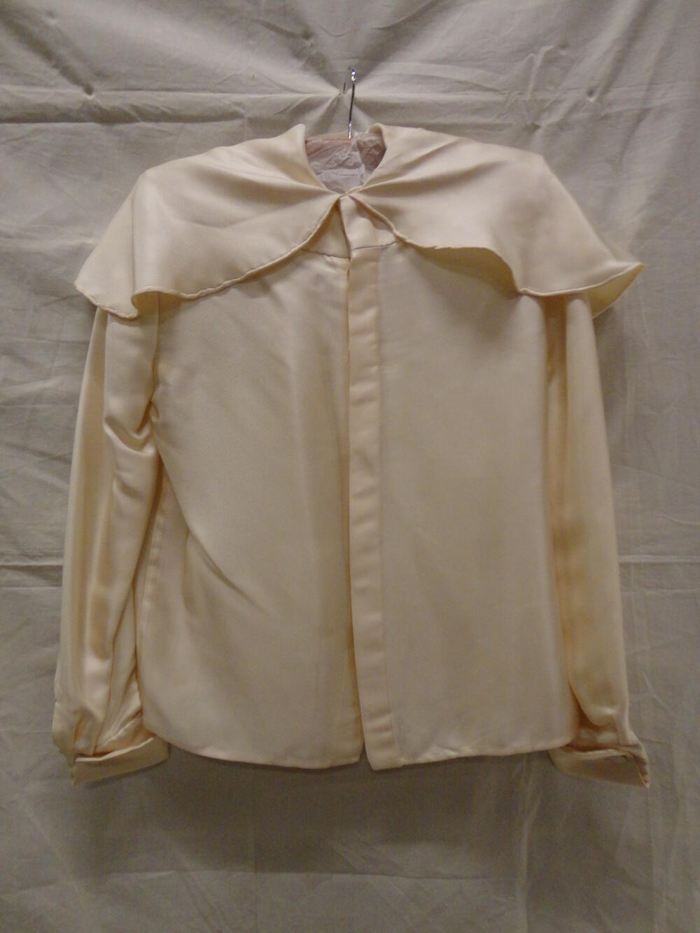 Blouse van crèmekleurig zijde in keperbinding met platte kraag in pelerine vorm