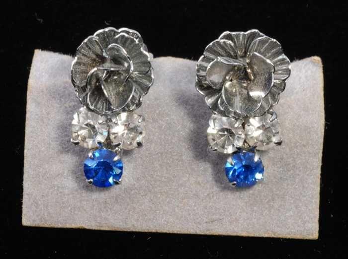 Eén paar oorbellen, clip met zilverkleurig bloemetje met één blauw en twee kleurloze…