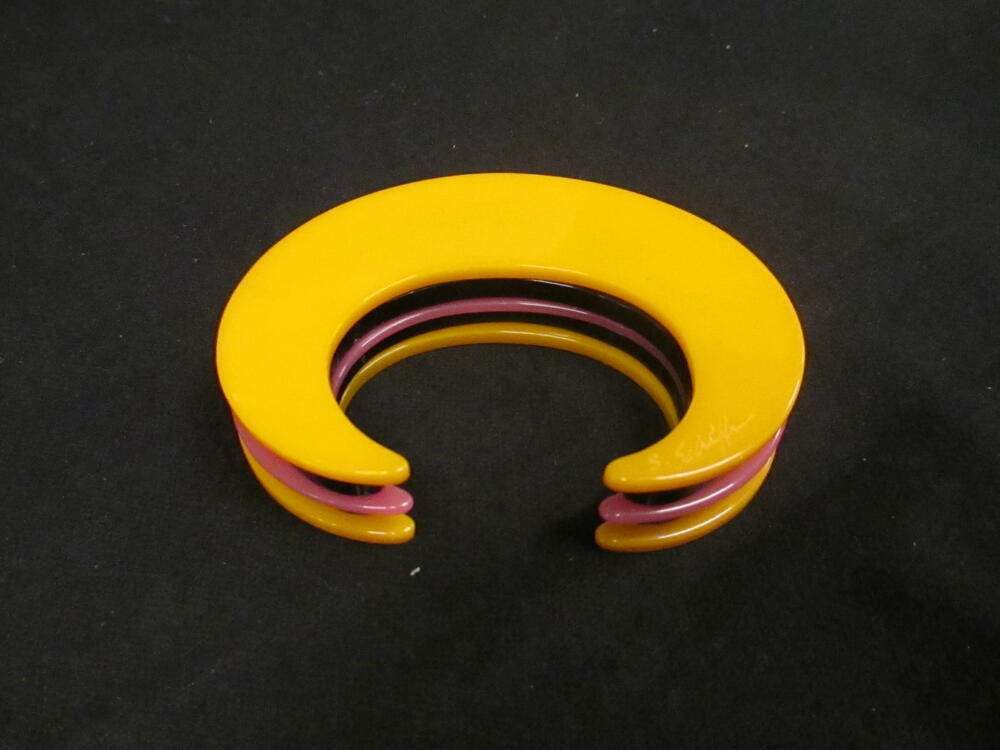 Armband, zogenaamde 'Philadelphia bracelet', C-vormig model opgebouwd uit kunststoflagen in oranje…