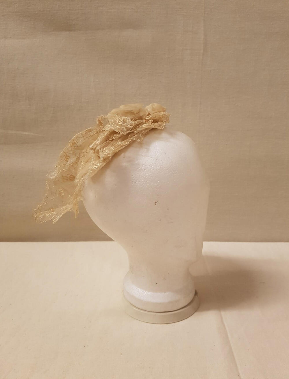 Coiffure / Kap bestaande uit stroken crèmekleurige effen organdie, machinaal geborduurd met…