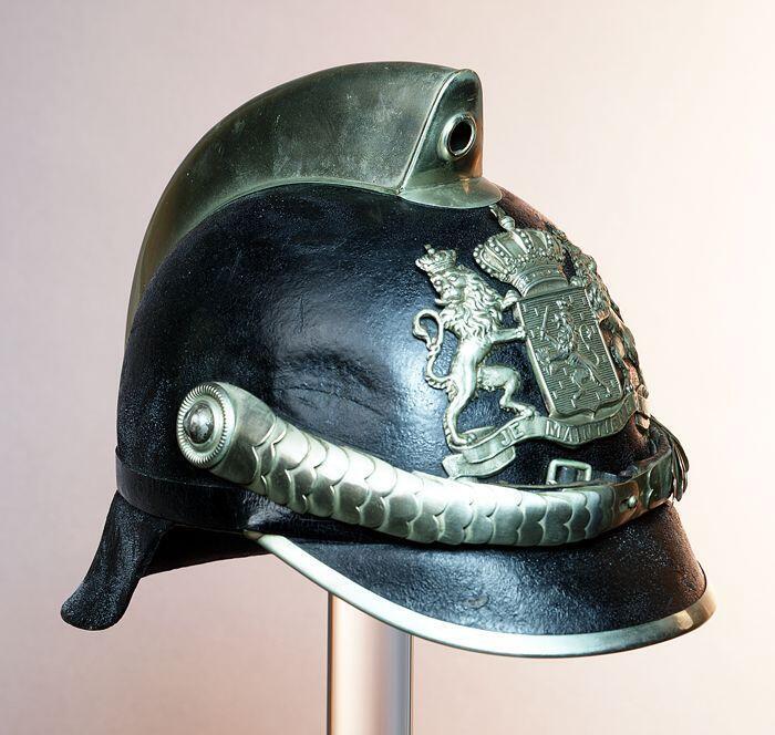 Politiehelm van zwartgelakt vilt met zilverkleurig metaalbeslag, rijkswapen in blank metaal,…