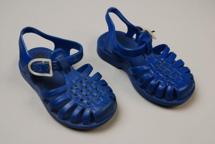 Blauwe plastic strandsandaaltjes met witte gespsluiting en vlechtwerk op de neus