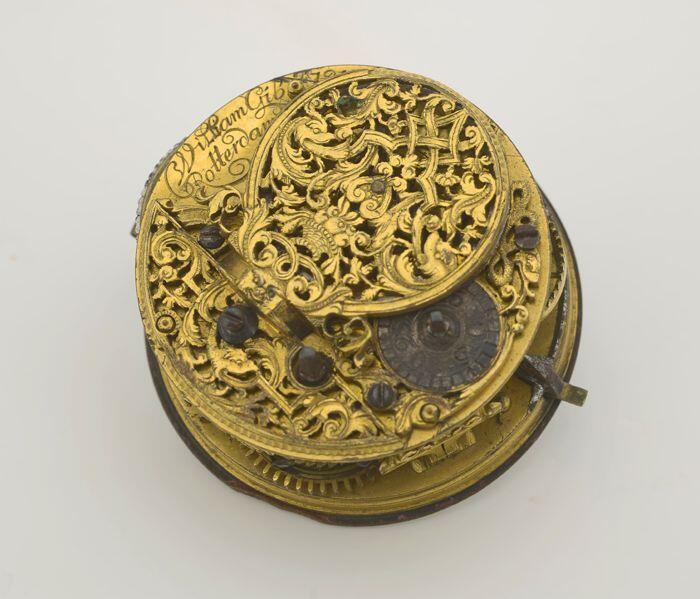 Binnenwerk van zakhorloge met wit-emaille wijzerplaat en gouden wijzer en ajourgezaagde kloof