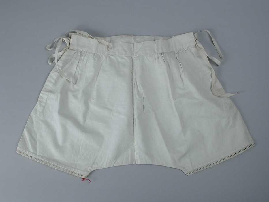 Kinderonderbroek van wit katoen strikbanden opzij, broderie langs korte pijpen