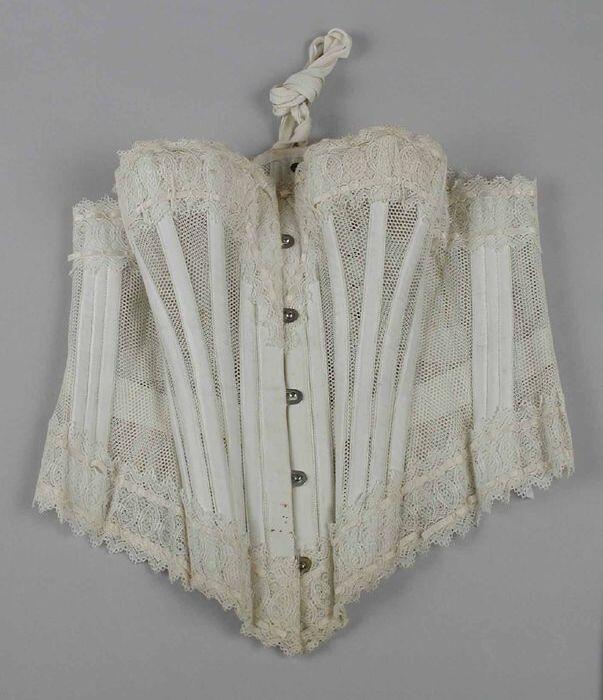 Korset (zomermodel), wit tule, met baleinen, boven- en onderrand strook gehaakt kant met wit lint,…