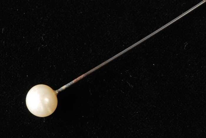 Hoedenspeld, korte metalen pin met scherpe punt, klein wit bol knopje van kunststof(?) met…