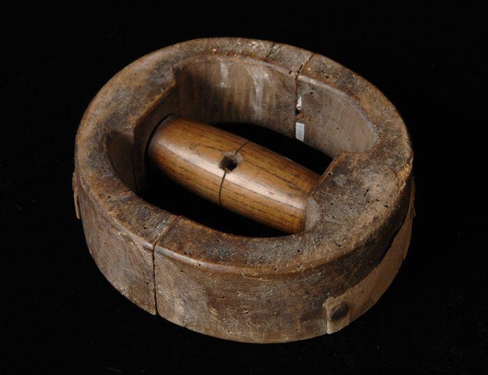 Hoedenmvale ring van donker hout uit twee delen met in het midden een handvat