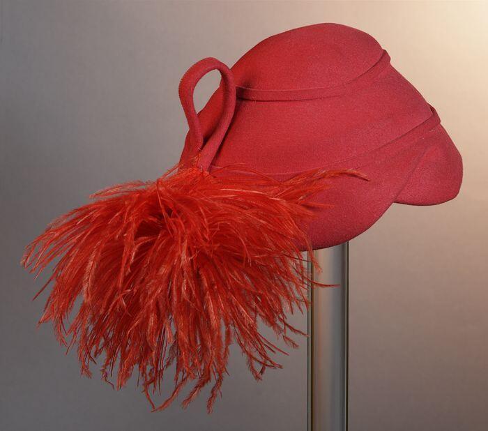 Kapje van rood vilt met toef rode struisveren