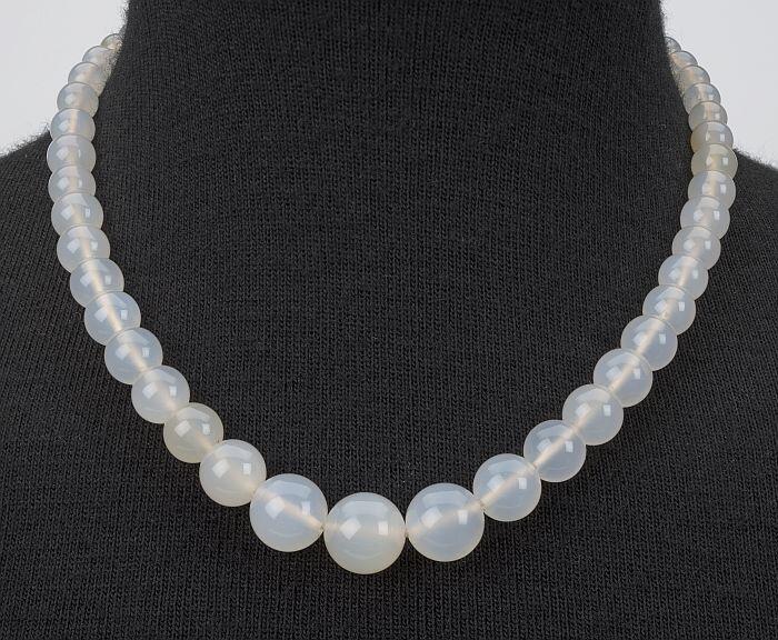 ketting met semi-transparante opaalwitte kralen, verschillend in grootte, met metalen slot