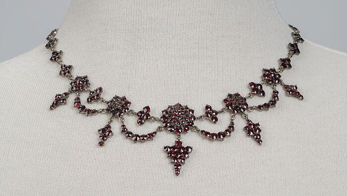 Parure van zilvermet granaat, bestaande uit een collier, broche, oorbellen en armband