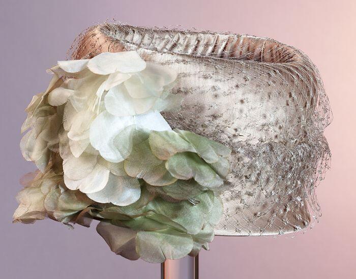 Toque van beige satijn, top open, gegarneerd met voile en bloemen van stof