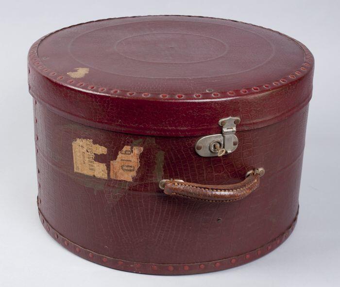 Ronde hoedendoos, handvat, slot, geheel bekleed met bordeaux rood leer met reptiel structuur,…