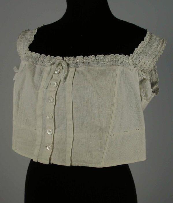 Reform korsetlijfje van wit kaaslinnen mouwloos kort model met broderie anglaise langs de vierkante…