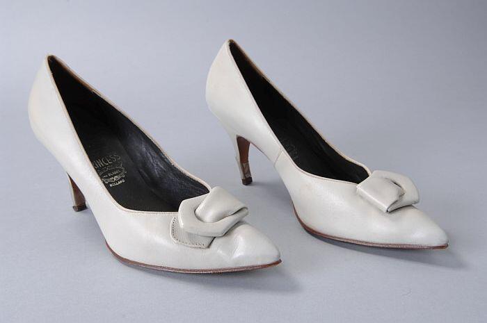 Lichtgrijze leren pumps met spitse neus, naaldhakken en siergesp op voorblad