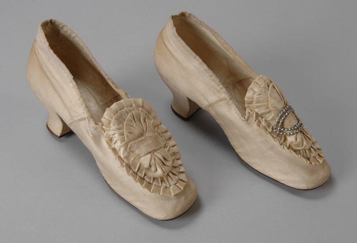 Witte satijnen bruidsschoenen met satijnen rozet met siergesp op de voorvoet en hoge louishak