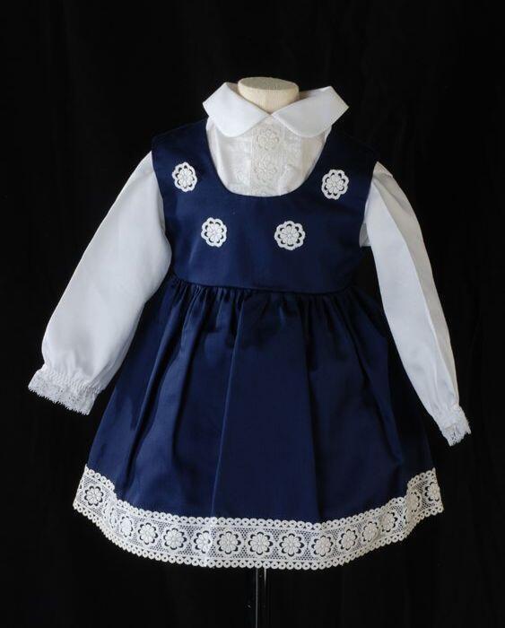 Tweedelige kinderjurk, witte blouse (2) met donkerblauwe overgooier (1) met wit kant,…