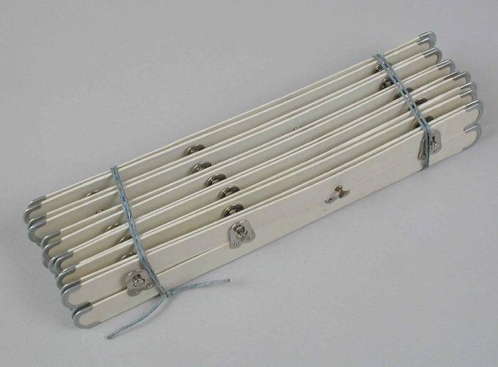 Zes gebundelde tweedelige bukssluitingen, twee metalen baleinen met wit papier beplakt en met vier…