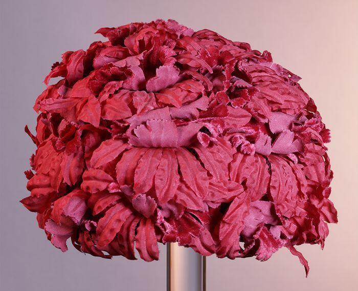 Ronde toque, geheel bedekt met rode bloemen van stof