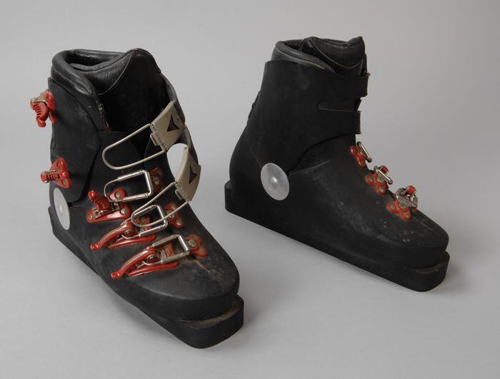 Paar skischoenen van zwart kunststof met rode sluitingen