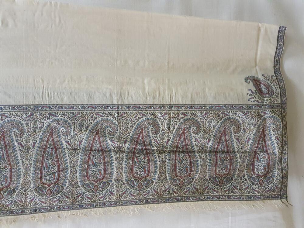 Shawl van wit cashmir, aan de korte kanten brede rand met arabesken, rondom smalle rand in diverse…