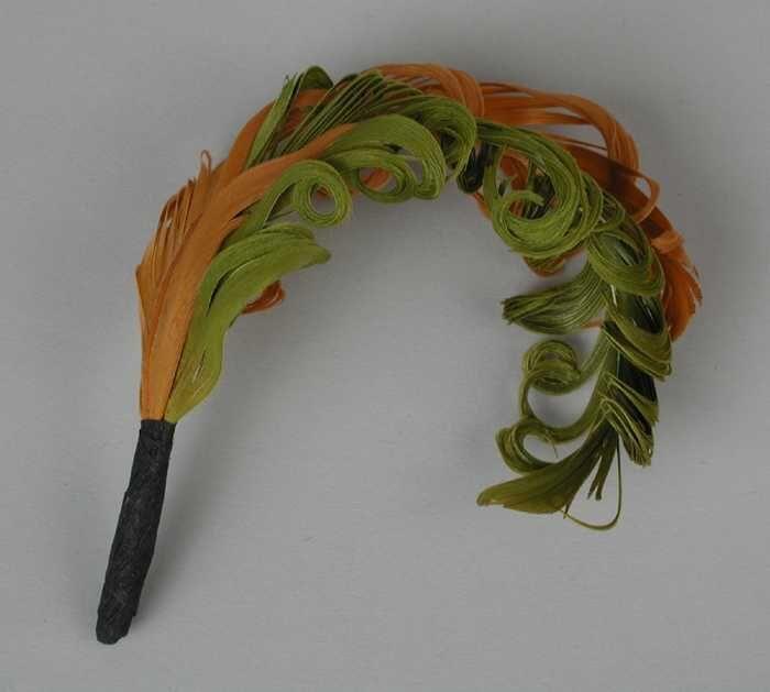 Veren hoedendecoratie of corsage, groene en oranje veer met gekrulde haren