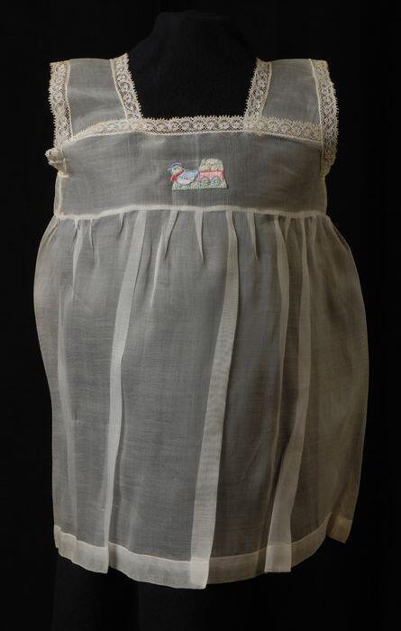 Babyjurk, mouwloos schortmodel van transparant wit nylonmet geborduurde vogel met bloemenkar, …