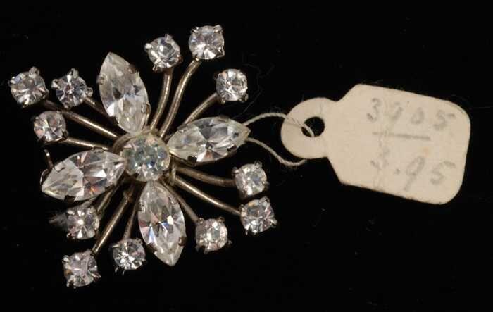 Eén broche, met veel kleine kunstdiamantjes in een stervorm in een zilverkleurige vattin, kapper…