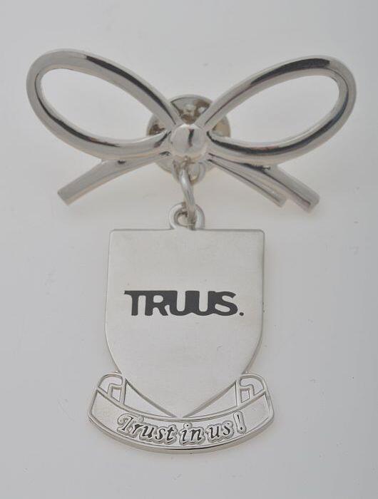 zilverkleurige speld van strik en hanger, Truus Trendy, "TRUUS. Trust in us!"
