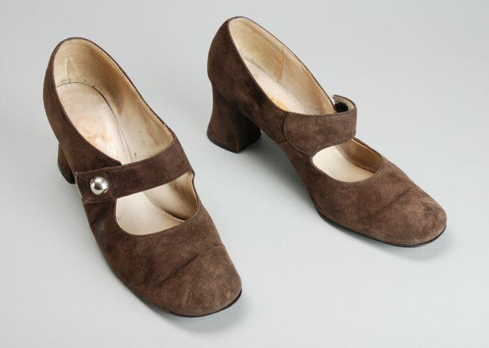 Paar damesschoenen van donkerbruin suède met brede hoge hak, wreefband met zilverkleurige knoop, …