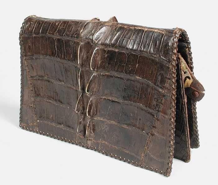 Enveloppetas van bruin krokodillenleer met rugpantser over het midden van de tas, gevoerd met zwart…