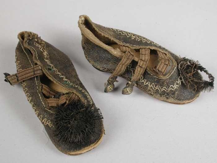 Paar miniatuur schoenen van zwart leer, wit sierstiksel rondom, lage hak en drie wreefbanden,…