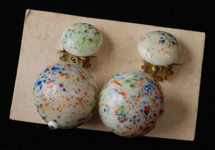 Paar oorbellen, clips met wit glazen bollen met gekleurde spikkels, op wit karton, kapper Van Vliet