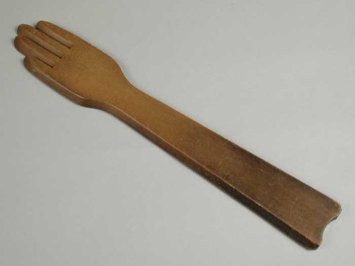 Handschoenhouder, smalle houten plank met aan het uiteinde een gestileerde hand, "wachter / 2"