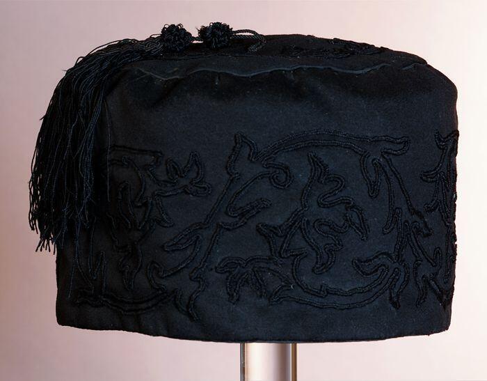 Ronde huismuts, zwarte zijde met zwart soutache in bladachtige vormen, sierkwast op bol