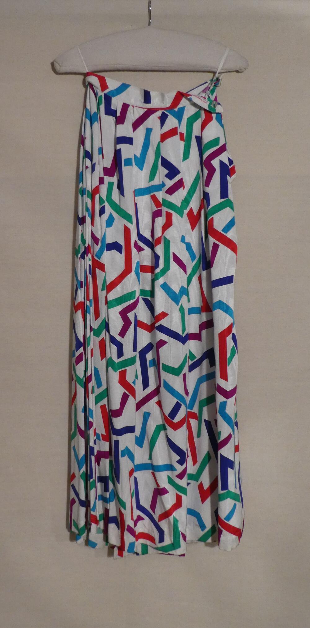 Rok van kunstzijde, wit fond met motieven in rood, groen, blauw, turquoise en paars, behorende bij…