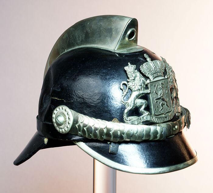 Politiehelm van zwartgelakt vilt met zilverkleurig metaalbeslag, rijkswapen in blank metaal,…