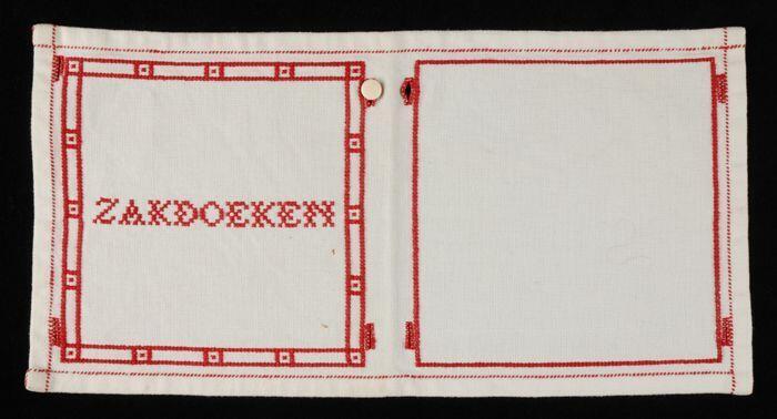 Zakdoekensachet, rechthoekige lap wit kaasdoek met in rood geborduurd "ZAKDOEKEN", acht knoopsgaten…