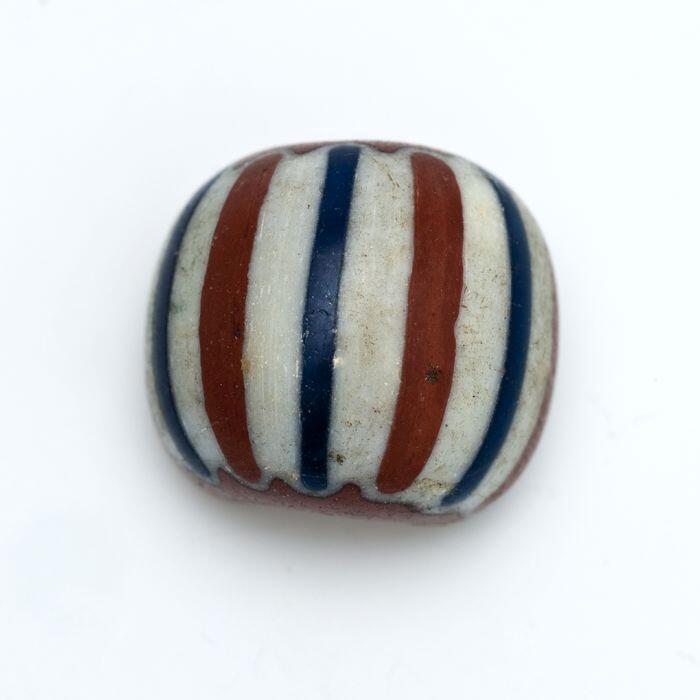 Ronde glazen kraal, rood-bruin met witte en blauwe strepen versierd