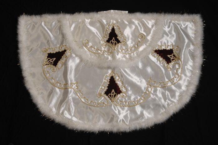 Witte cape bij Turks besnijdenispak, versierd met goudkleurige veterband en rode ruiten