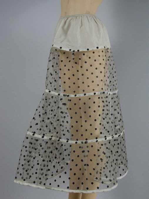 Witte nylonpetticoat van zeer stug wit gaas met zwarte stippen van fluweelachtig materiaal,…