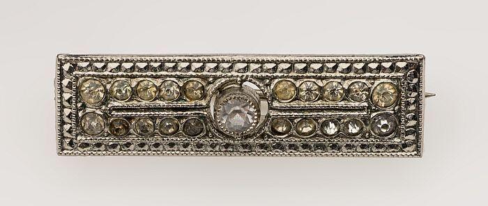 Broche bezet met strass-steentjes, centraal één grotere