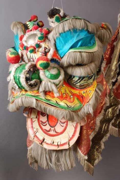 Fantastische kop van een Chinese leeuw, van metaal en papier maché, blauw en oranje, onderdeel van…