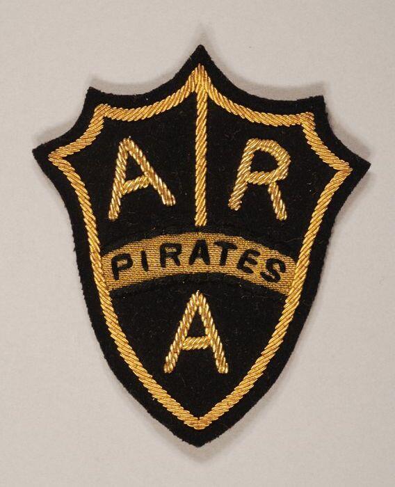 Stoffen badge "ARA" "Pirates", schildvormig zwarte ondergrond met gouddraad opgestikt drie gouden…