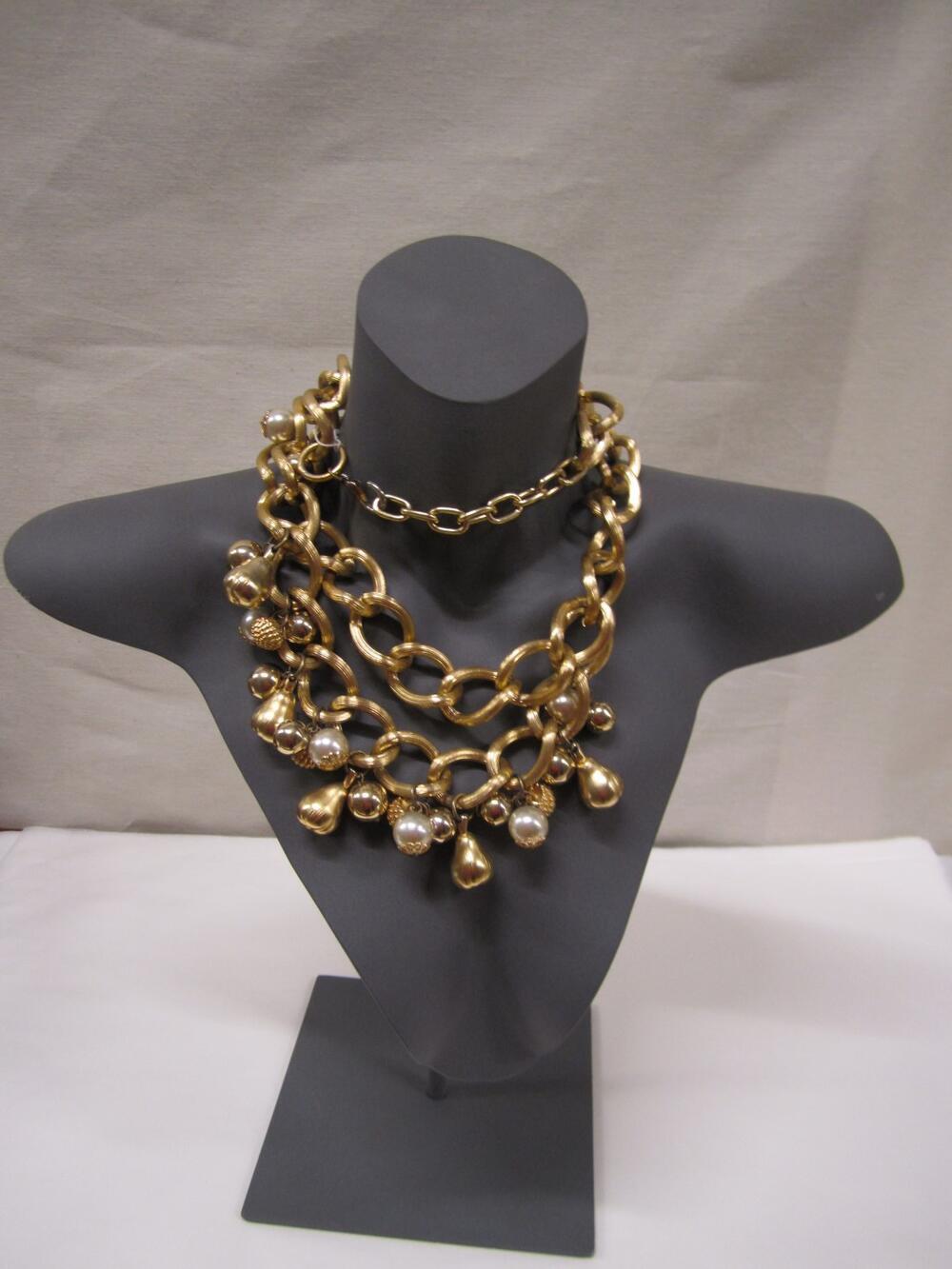 Ceintuur in vorm van grove schakelketting. In midden van ketting extra ketting gevestigd, waaraan…